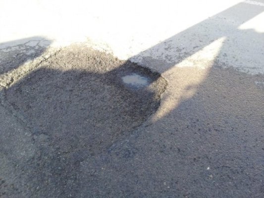Groapă cu atitudine pe strada Portiţei: după ce a fost astupată de o armată de oameni, a reapărut!